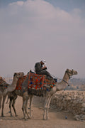 Tourist riding a camel in front of the Giza Pyramids