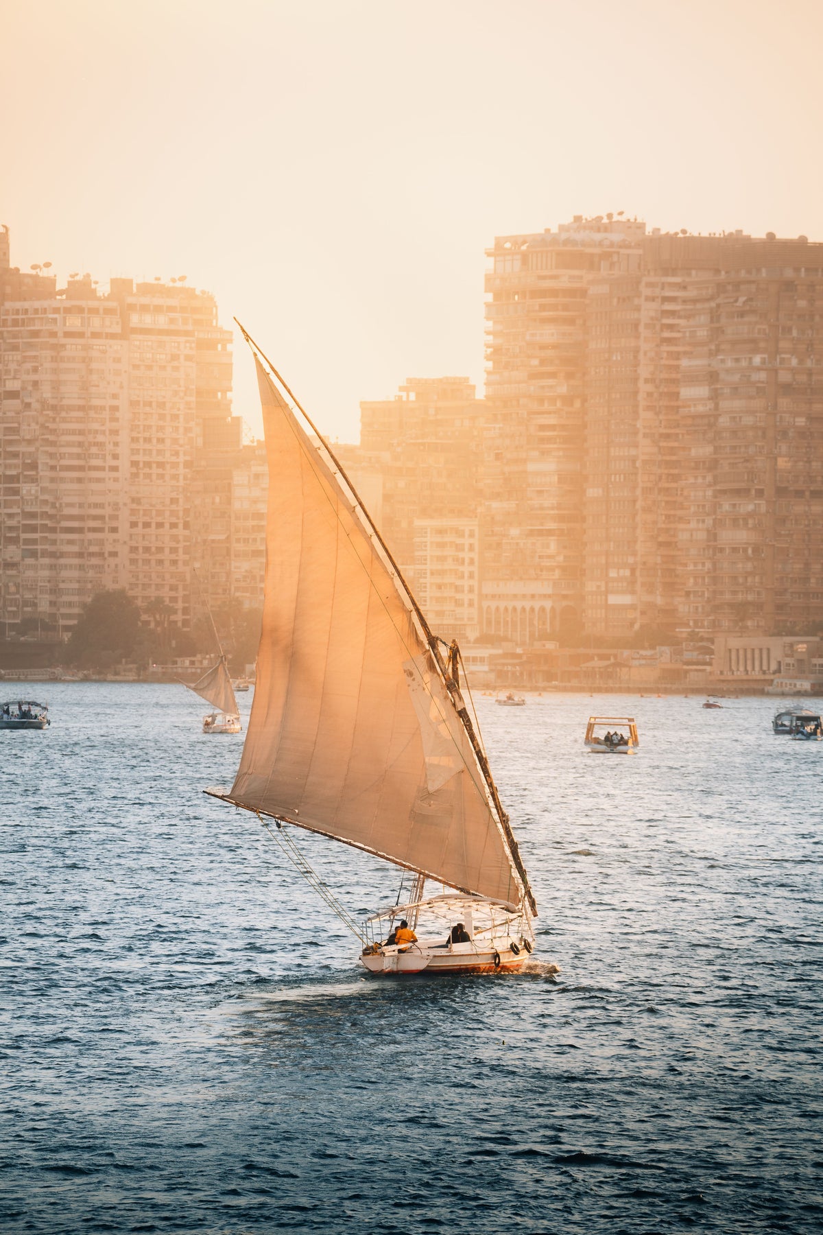 Traditional felucca sailboat on the Nile River at golden sunset